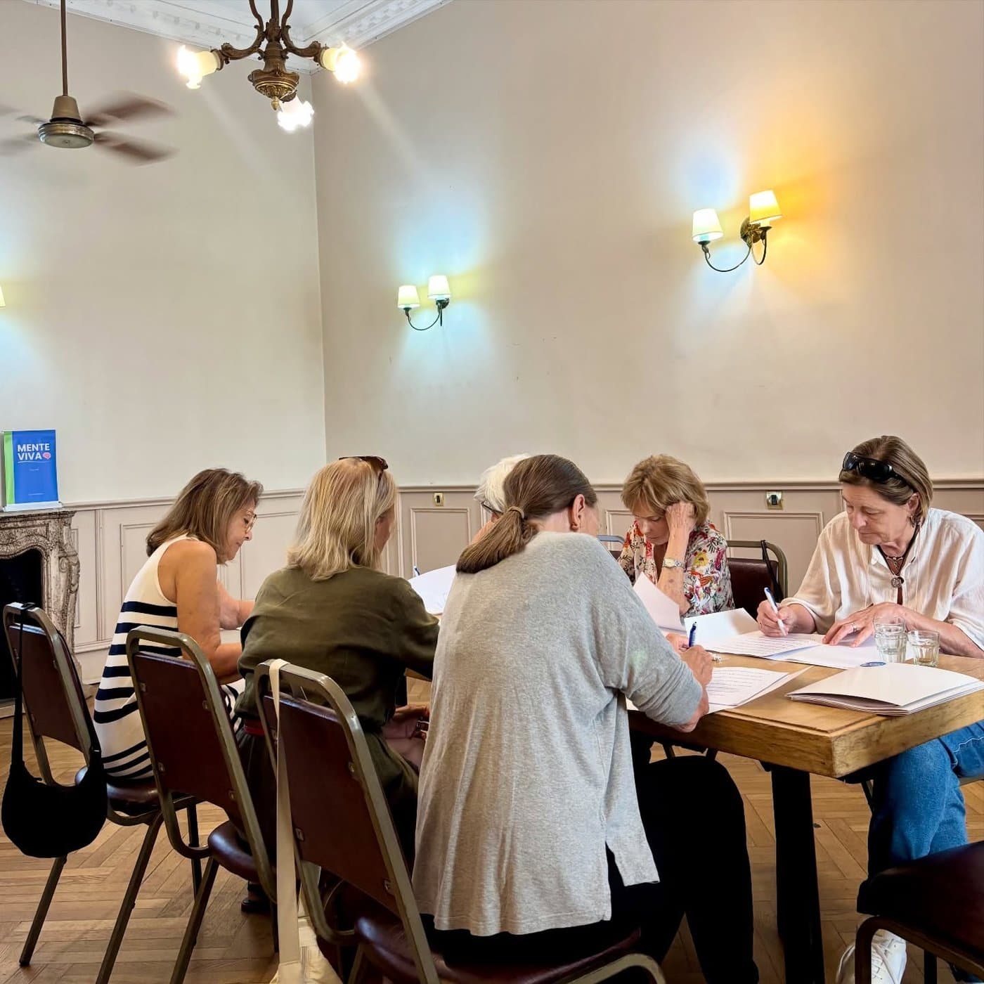Grupo del Club Social compartiendo actividades en una mesa del Palacio Balcarce